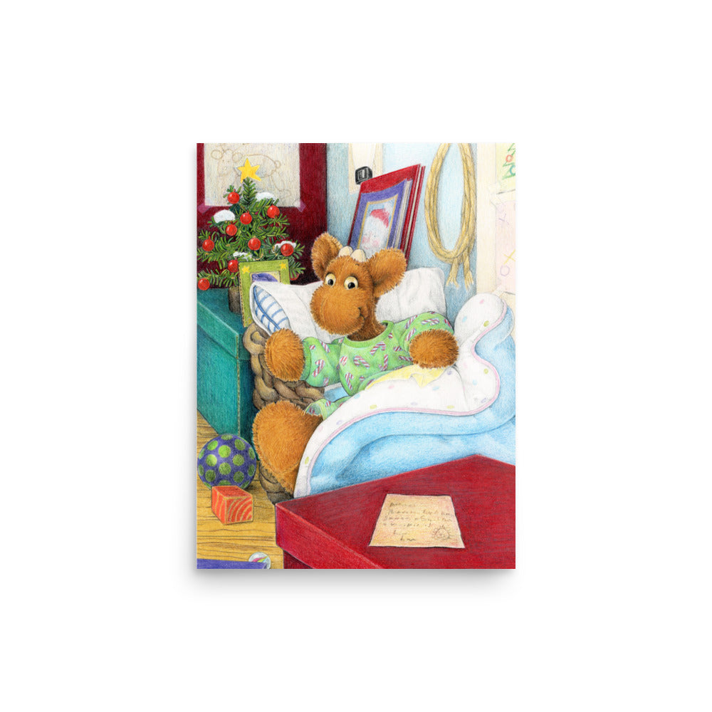 Elliot Moose a children's book character, is jumping out of his basket bed to look at a big red box at the end of his bed. A Christmas tree is in the back ground. From the Book Elliot's Christmas Surprise by Andrea Beck