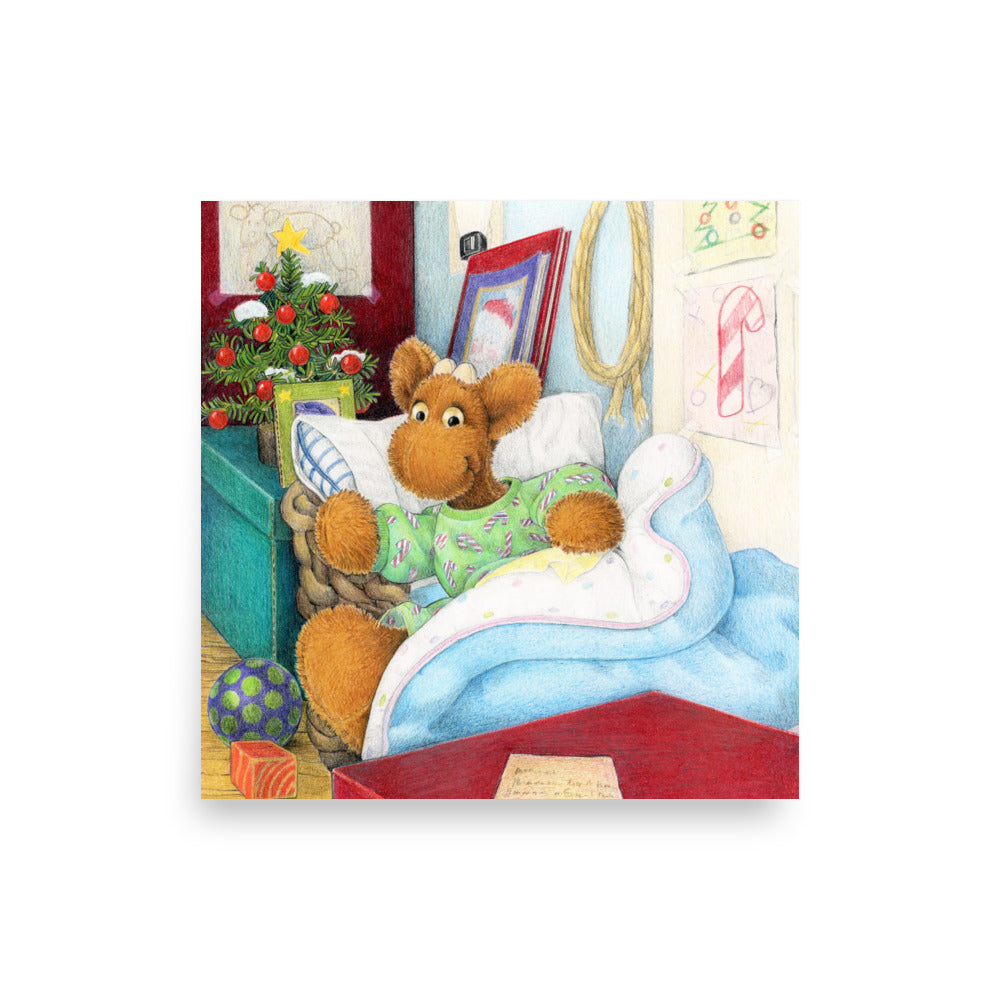 Elliot Moose a children's book character, is jumping out of his basket bed to look at a big red box at the end of his bed. A Christmas tree is in the back ground. From the Book Elliot's Christmas Surprise by Andrea Beck