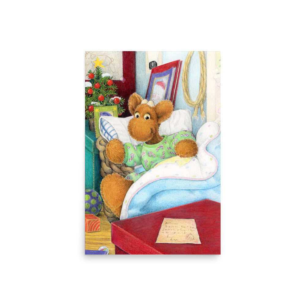 Elliot Moose a children's book character, is jumping out of his basket bed to look at a big red box at the end of his bed. A Christmas tree is in the back ground. From the Book Elliot's Christmas Surprise by Andrea Beck