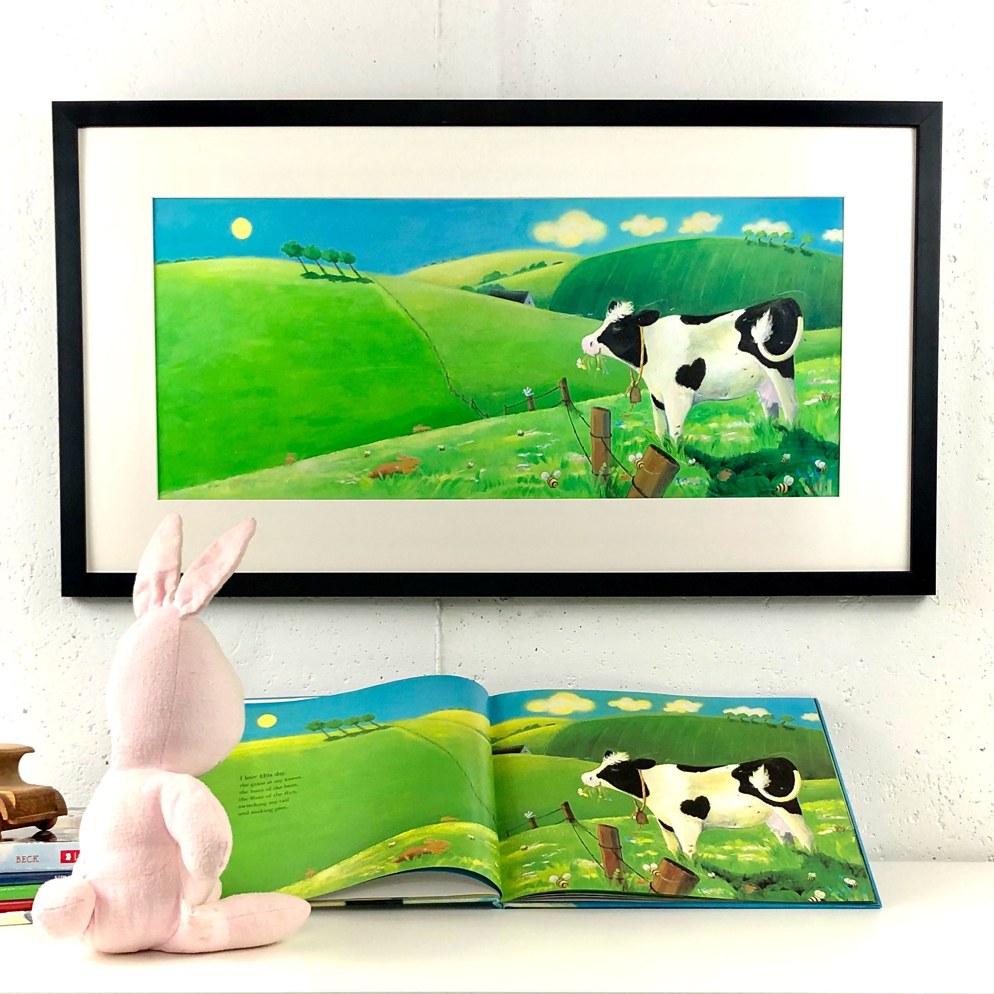 Picture book art from Buttercup's Lovely Day by Carolyn Beck. Art by Andrea Beck. Nursery Decor. Cow Art. Picture book posters. Bunny reads a page of Buttercup's Lovely Day.